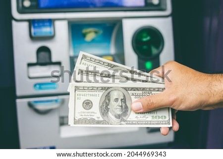 Young man take the money from atm machine. Business man hand put the credit card and password into atm to withdraw the lot of money. Holding cash in front of banking.