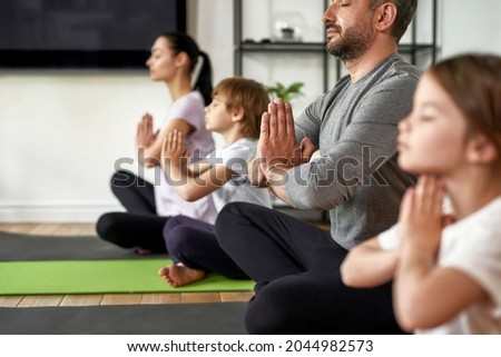 Crop close up of mindful young family with children sit meditate with mudra hands practice yoga. Calm Caucasian parents with kids have meditation session breathe fresh air relieve negative emotions. Royalty-Free Stock Photo #2044982573
