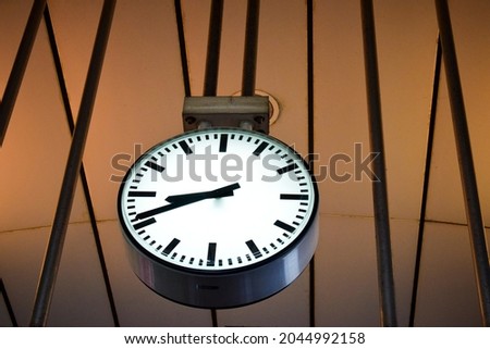 Minimal style white clock, hanging from the wall.