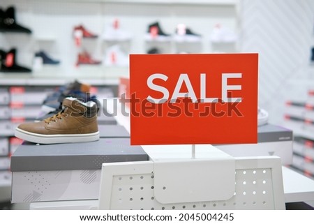 Sale sign notice into a clothes store. Shopping mall advertisement.