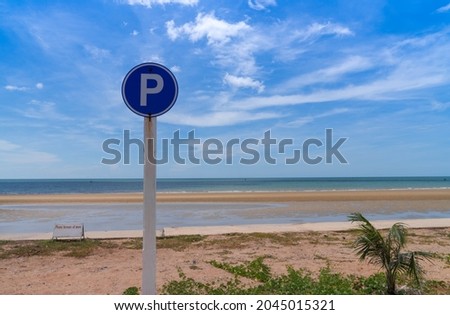 P sign in circle traffic symbol for parking near beach view with bright cloudy blue sky. sunny day. summer vacation.