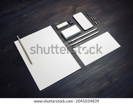 Photo of blank stationery set on wooden background. Mockup for design presentations and portfolios.