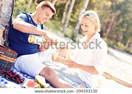 A picture of a young romantic couple having picnic at the beach