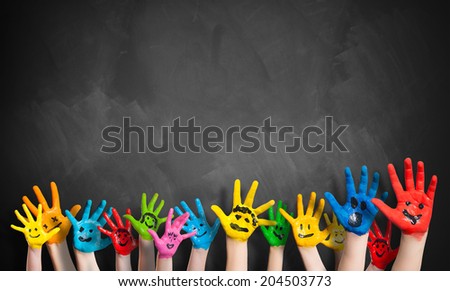 painted hands in front of a blackboard