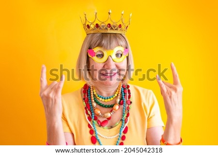 Crazy senior woman funky action smile. Happy smiling senior man on yellow background. Concepts about senior people retirement, happiness in old age, pensioner and mature people, new seniors.