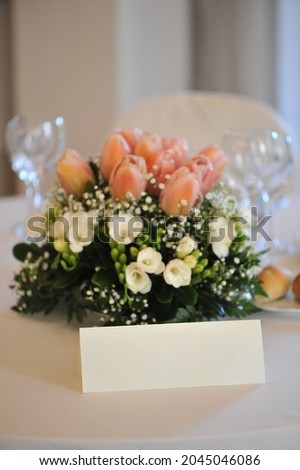 Table of the newlyweds in the restaurant with flower arrangement as centerpiece