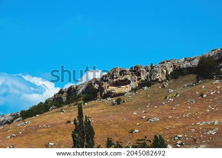 Mountains of a bizarre shape with a gap inside on the slope. Crimea