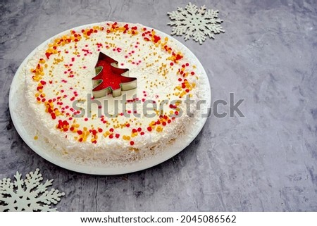 Christmas cake with white cream and a red gold  Christmas tree made of sprinkles. Homemade Christmas cake in red and gold flat lay copy space. Christmas food background top view