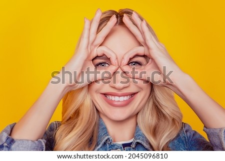 Portrait of lovely cute pretty lady show okey signs cover eyes make binoculars watch on yellow background