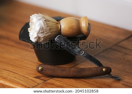 Set of shaving equipment and men's cosmetic products on wooden table, barbershop. shave concept with a straight razor, shaving brush and foam Royalty-Free Stock Photo #2045102858