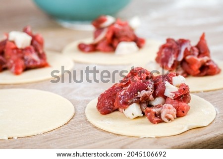 A man is holding a khinkali in close-up. Cook in the kitchen. The process of preparing a national dish