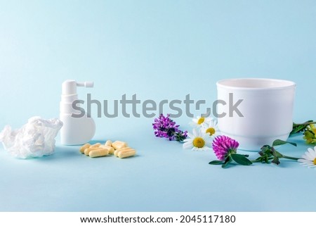 Cup of tea with flowers chamomile and blooming Sally and pills, spray for runny nose and throat. Seasonal diseases and treatment of colds, flu, heat. Herbal medicine vs conventional medicine Royalty-Free Stock Photo #2045117180