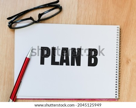 Text PLAN B written on note book with a pen and eye glasses.
