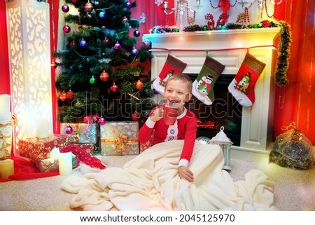 happy boy is drinking milk. Christmas Eve