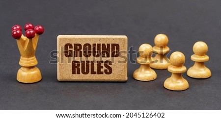 Business concept. On a black background, chess and a sign with the inscription - GROUND RULES