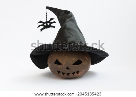 A pumpkin made from clay. Pumpkin for Halloween, the pumpkin is wearing a witch hat. Attributes for the holiday on a white background