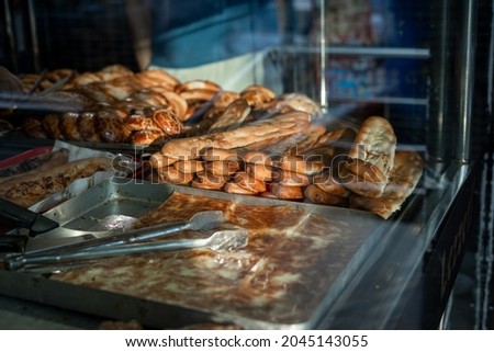 Pita and pastries in metal tray through the glass