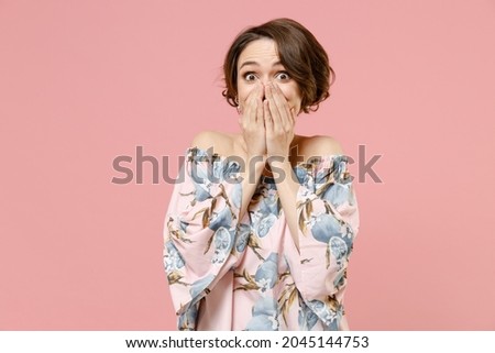 Young shocked amazed impressed astonished confused woman with short hairdo wearing trendy blouse covering mouth with hands arms isolated on pastel pink color background studio People lifestyle concept