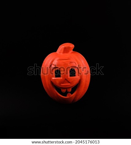 Orange pumpkin mask against black background. Minimal Halloween concept