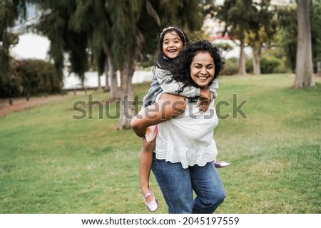 Happy indian mother having fun with her daughter outdoor - Focus on mother face Royalty-Free Stock Photo #2045197559