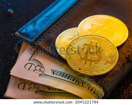 50 dollar bills in a leather wallet and gold bitcoins. Cryptocurrency. New financial technologies, electronic money, exchange, sale and purchase of currency. There are no people in the photo.