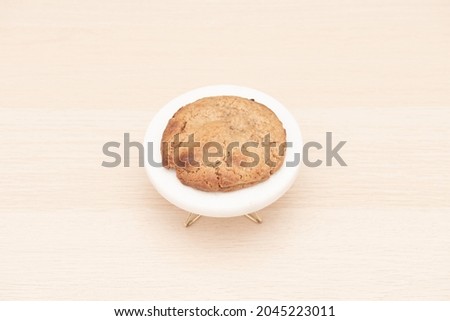 Freshly baked caramelized white chocolate cookie on light wooden table