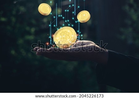 A man holding show bitcoin.Cryptocurrency on hand and graph for bitcoin.Blockchain technologies,finance digital money market,photo modern technology and Digital cryptocurrency concept.