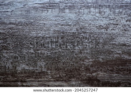 A fragment of aged black wood with traces of rough processing. Background, pattern, texture.