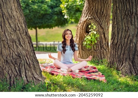 Full length body size photo woman sitting on blanket in park doing yoga asana relaxing