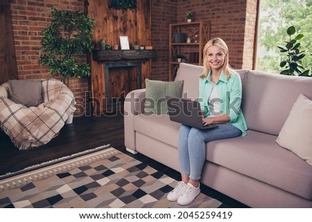 Full length body size photo woman smiling using laptop typing message staying at home