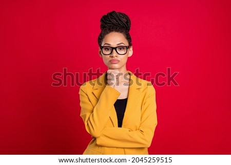 Photo of serious staring lady hand chin wear eyewear yellow cardigan isolated on vivid red color background