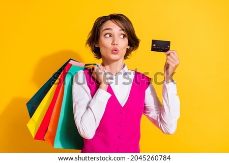 Photo of shocked pretty young woman dressed pink suit holding shopping bags looking credit card isolated yellow color background