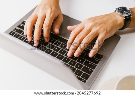 Male hands typing on keyboard, Man using laptop in home office
