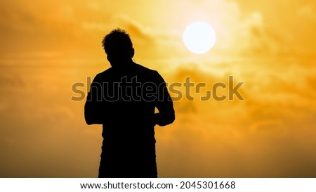 Man relaxing on the beach at sunset, silhouette view. Relax and holiday concept.