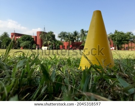Yellow Sports training cone on the ground with background blur blue sky.