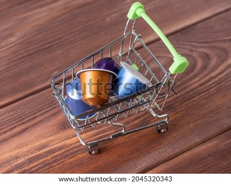 a small grocery cart full of colored aluminum capsules with aromatic ground coffee. Modern technologies of coffee storage and preparation