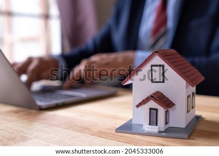 Man signing a contract when buying a new house Purchase agreement for ours with model home, Man sign a home insurance policy on home loans, Businessman signing contract insurance, Real estate concept