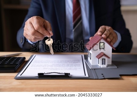 Real estate agent hand over the keys during meeting after signing rental lease contract or sale purchase agreement And congratulate buyers after giving buyers a purchase contract.sign contract concept