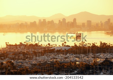 San Diego downtown skyline at sunrise with boat in harbor.
