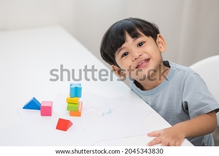 Asian little boy education from home. Developing children's learning before entering kindergarten Practice the skills of playing with wooden toys in living room.