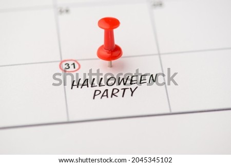 Above photo of label date 31 october with inscription halloween party with red pin isolated on the calendar background