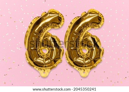 The number of the balloon made of golden foil, the number sixty-six on a pink background with sequins. Birthday greeting card with inscription 66. Numerical digit, Celebration event, template.
