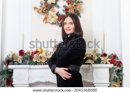 Christmas Santa. Beautiful smiling woman model. Makeup. Elegant lady in red skirt and black jacket over christmas tree lights background. happy new year.