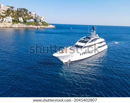 Aerial view of luxury yacht cruising in deep blue sea near Mediterranean. Drone tracking photo of modern yacht preparing to speed in Nizza, côte d'azur, Franch Riviera. Big white modern boat.
