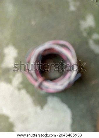 Defocused abstract background of a bundle wires is wound around the floor for the lamp connection.