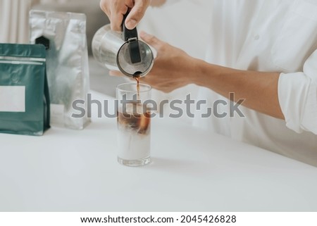 Man making coffee with equipment at home. Happy man pouring coffee in a cup and making coffee at home.
