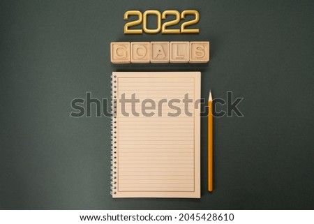 New Year goals 2022 with notebook  of new year goals and resolutions setting. flat lay style. Christmas planning concept.