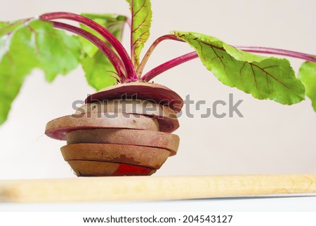 sliced raw beetroot with leaves on cutting board 