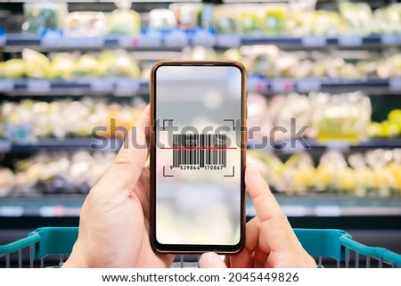 Smart retail concept.Female hands using barcode scan for information of product in supermarket with her mobile phone Royalty-Free Stock Photo #2045449826