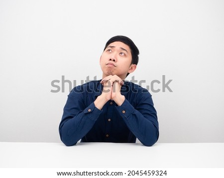 Young man sitting at the desk and wish for something